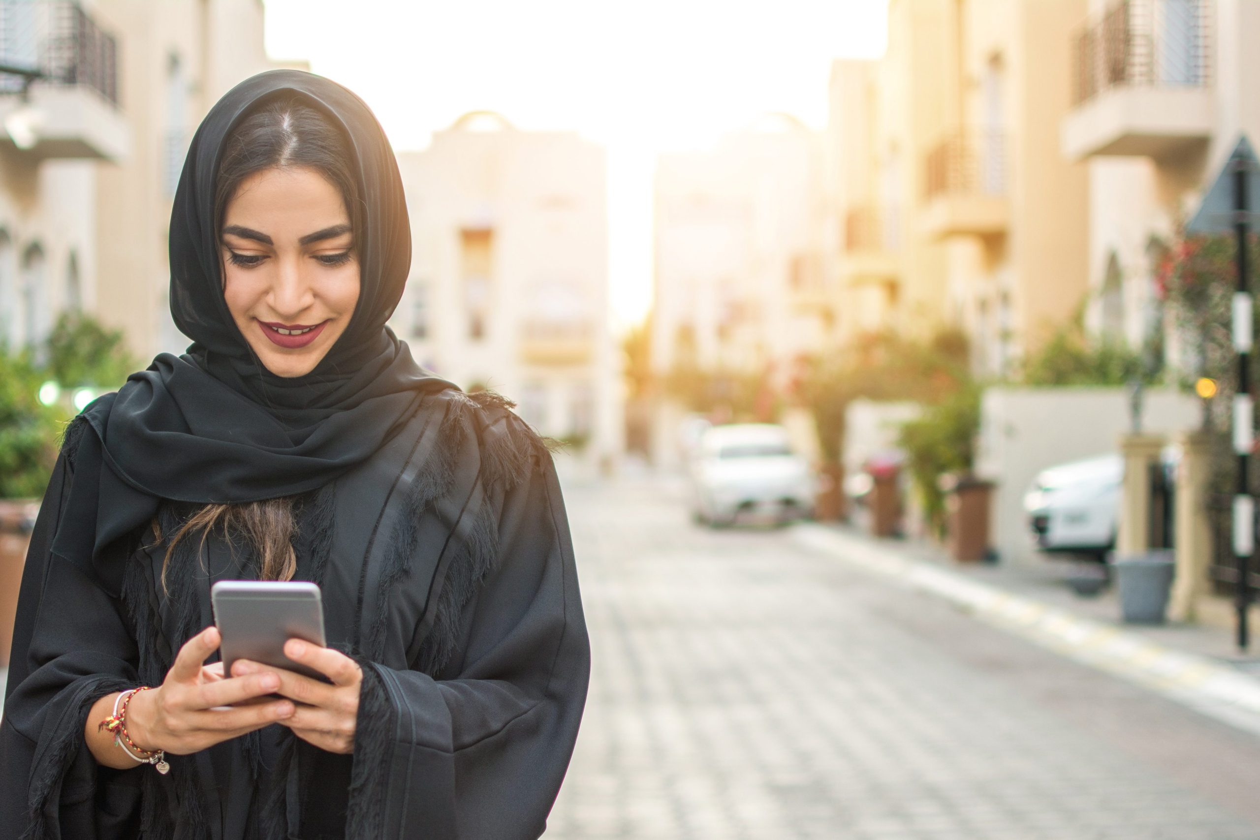 A woman in a head wrap on her phone