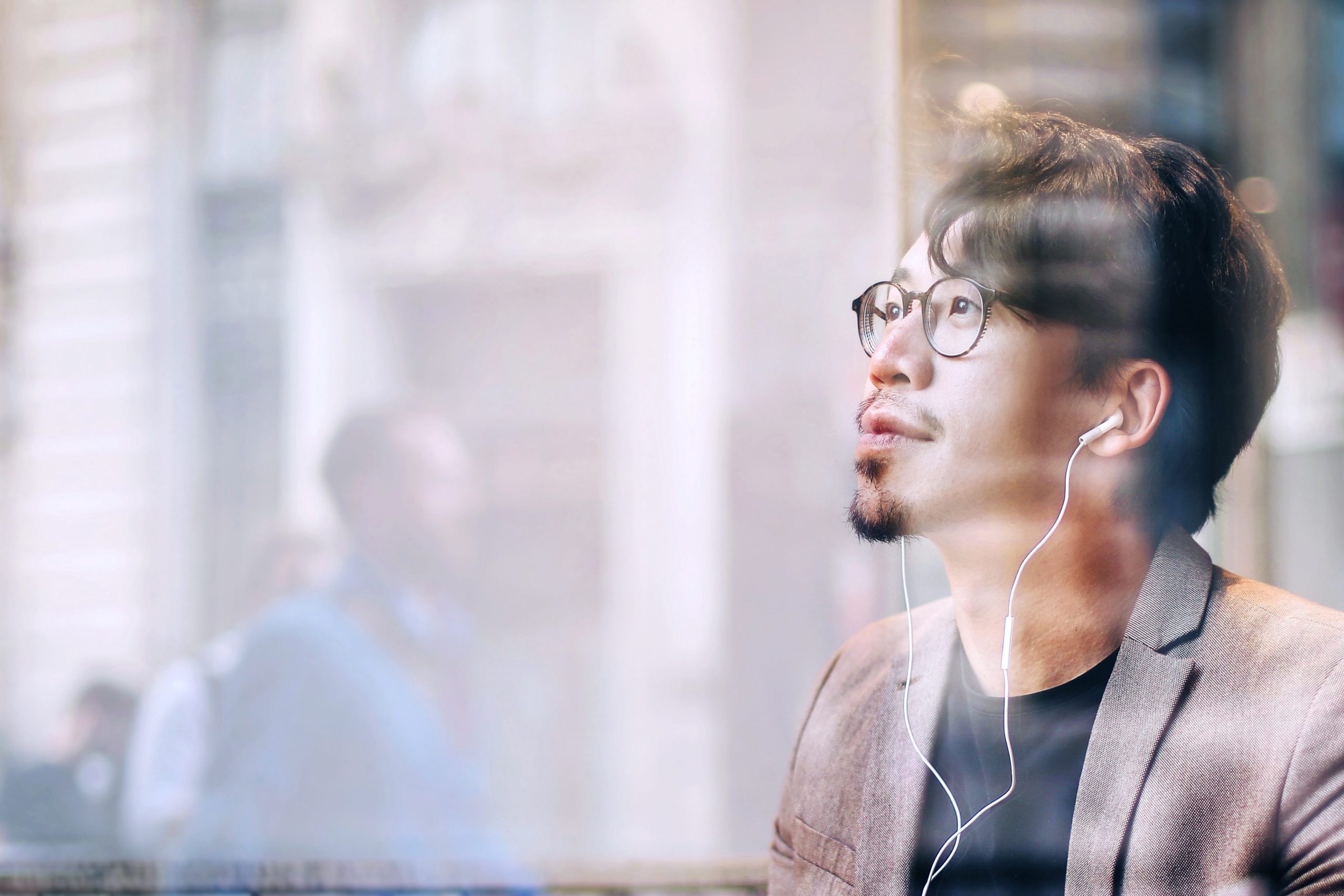 A man of Asian heritage wearing earphones